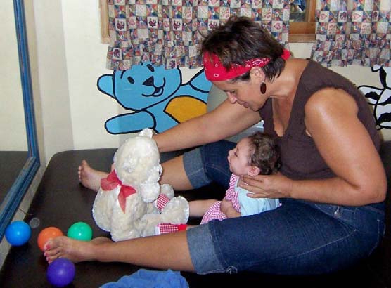 Jacque provides physical therapy at Familias Especiales for a handicapped child (on a therapy table donated by SRW!).