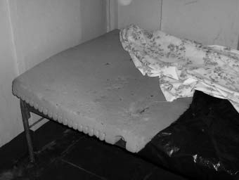 The beds are rusted shells with foam or folded blankets on top.